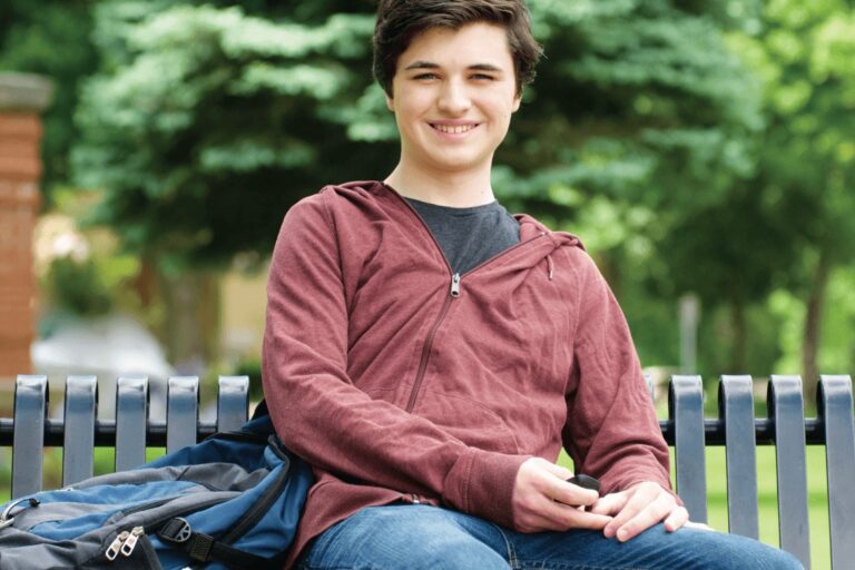 College-Student Male college student sitting on bench with back pack