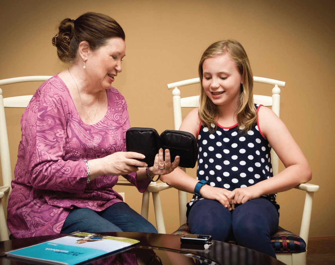 Linda teaching young girl how to use her diabetes supplies