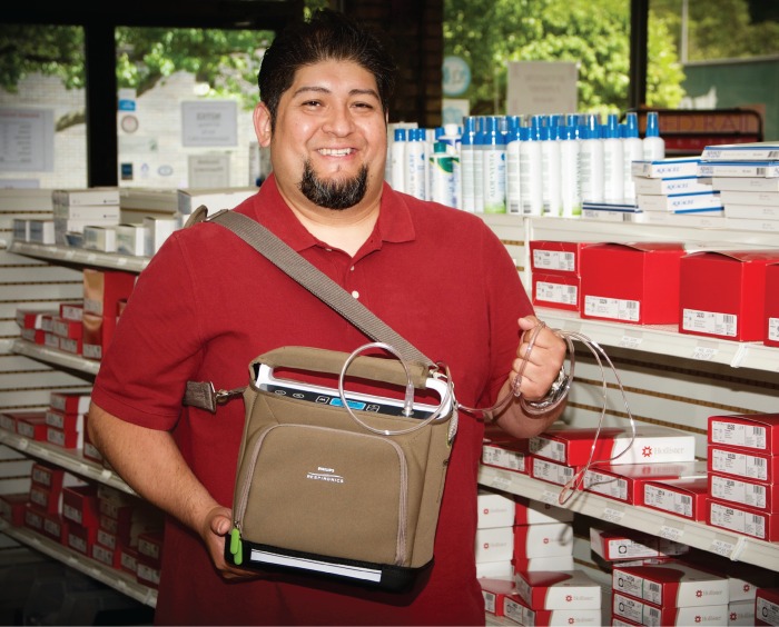 Doubek Team Member in show room holding an oxygen compressor