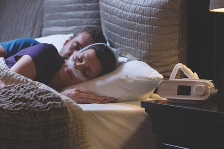 Dreamstation PAP therapy system Woman wearing her CPAP nose mask and sleeping