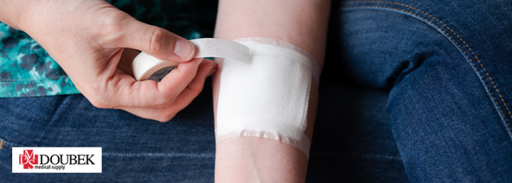 Doubek-WoundCare101 Person wrapping their wound with a gauze and taping it with white tape
