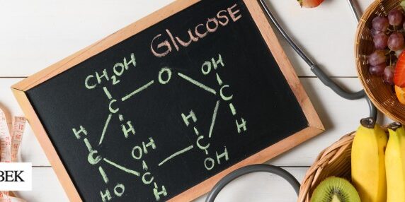 Chalkboard with glucose breakdown written out and fruits in bowls around the board.