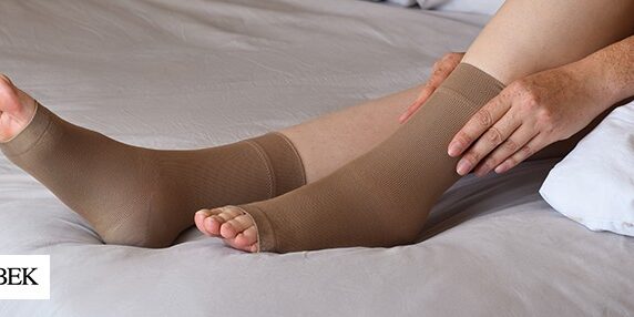 Doubek-CompressionSock Woman pulling compression sock onto foot