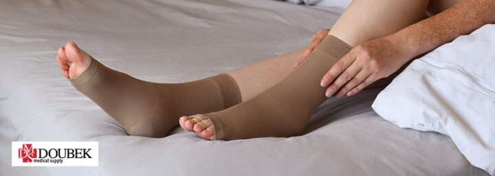 Woman pulling compression sock onto foot