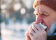 Man outside in the winter holding a tissue to his nose and over his mouth