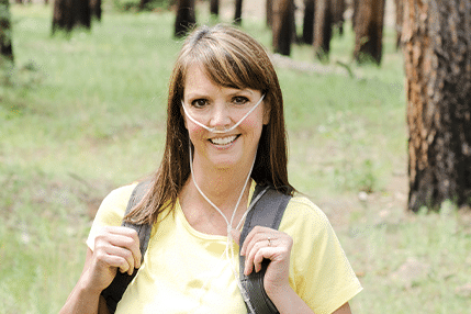 Woman outdoors with an oxygen pack on her back