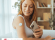 A woman using her phone to check her CGM